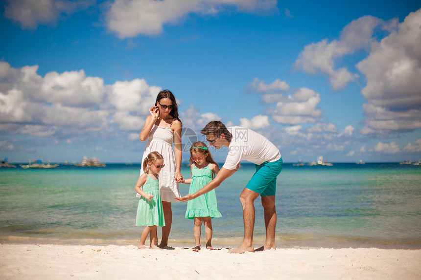 年轻美丽的家庭 有两个孩子在热带海滩散步的青春图片