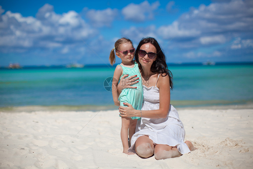 年轻美丽的母亲和在热带海滩的可爱的小女儿 幼美的母亲海岸女士孩子海岸线享受异国婴儿父母女性女孩图片