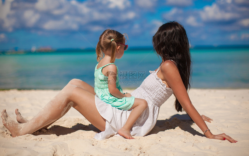 年轻美丽的母亲和在白沙滩上的小女儿图片