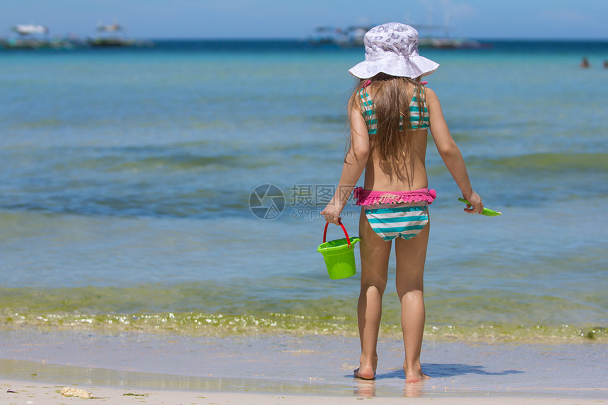 穿着美丽的泳衣的可爱小女孩 在热带散步时走着图片