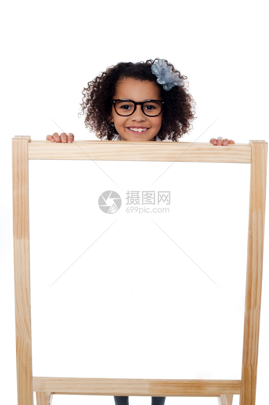 女孩从白色写字板后面偷看小学生冒充画架卷发孩子班级学校幸福空白隐藏图片