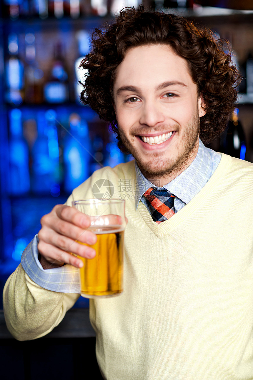 拿着啤酒的正阳性青年男子餐厅玻璃享受娱乐快乐男人夜店庆典卷发酒吧图片