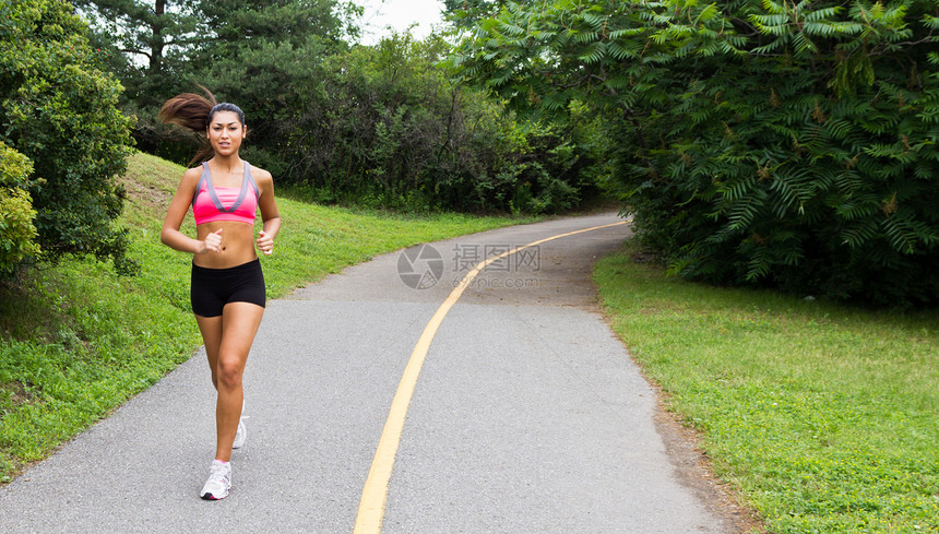 微笑的年轻女子为健身而奔跑福利训练跑步女人女性女孩女士慢跑文胸耐力图片