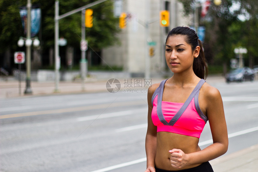 合适的年轻女子在繁忙的街道上奔跑娱乐跑步文胸活力福利耐力女士运动员训练慢跑图片