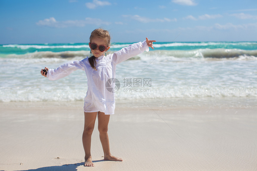 美丽的小女孩张开双臂 站在白沙滩上情调女孩热带旅游婴儿海岸自由海滩童年支撑图片