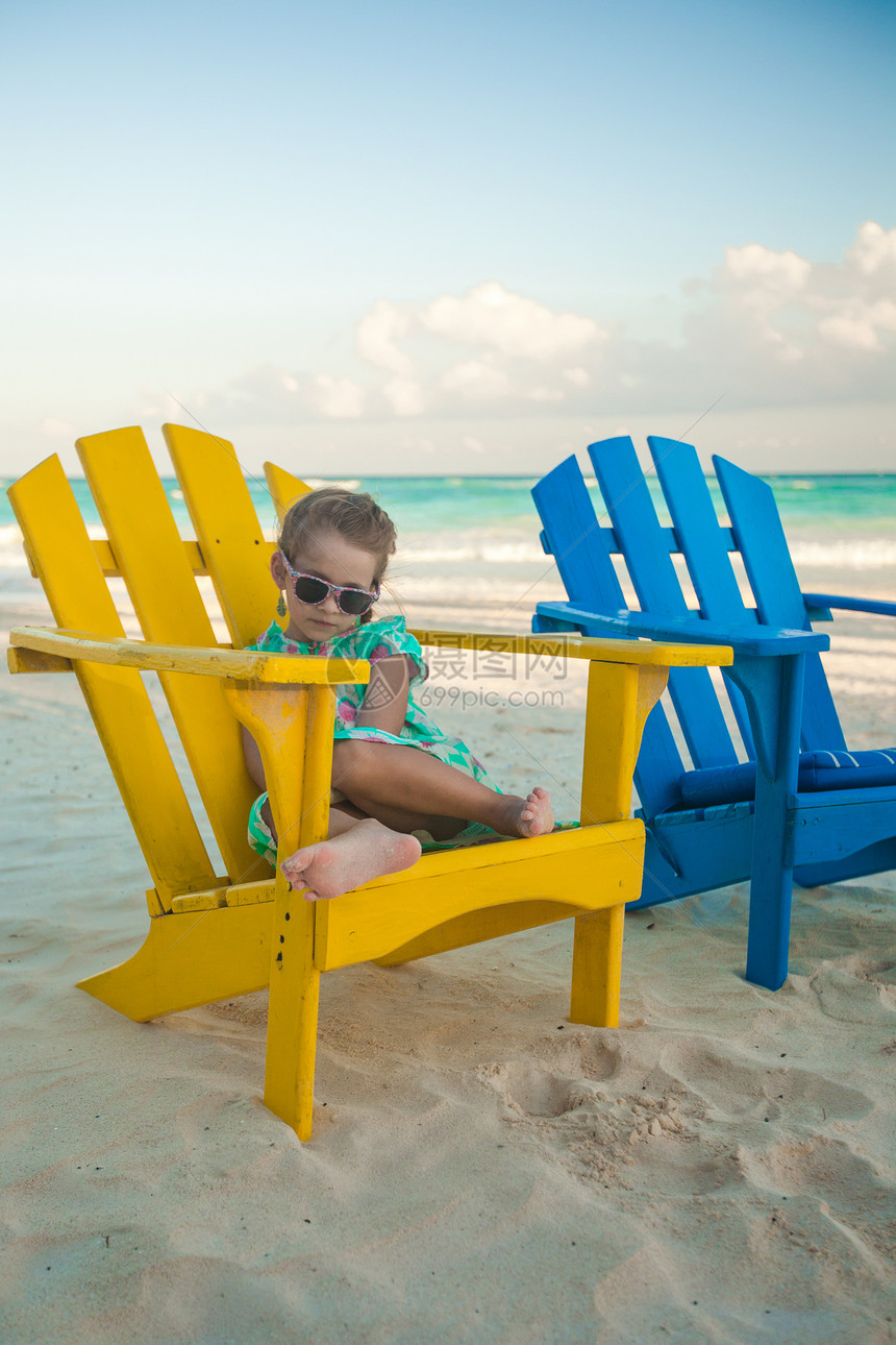 墨西哥Tulum热带海滩上沙滩木制多彩椅子上的小女孩风景休息室海岸线海岸蓝色海景情调海洋异国假期图片