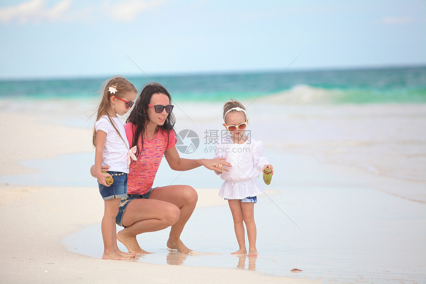 年轻母亲及其可爱的女儿们在热带海滩享受暑假 并在热带海滩度假男人女儿异国海洋假期男性海岸线婴儿女孩父母图片