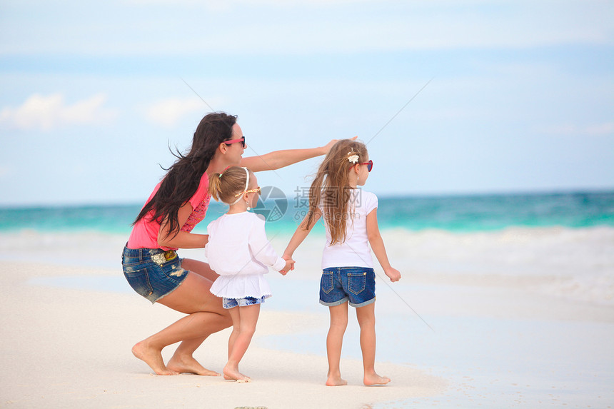 年轻母亲及其可爱的女儿们在热带海滩享受暑假 并在热带海滩度假婴儿乐趣假期爸爸海岸线妈妈家庭男性海岸情调图片