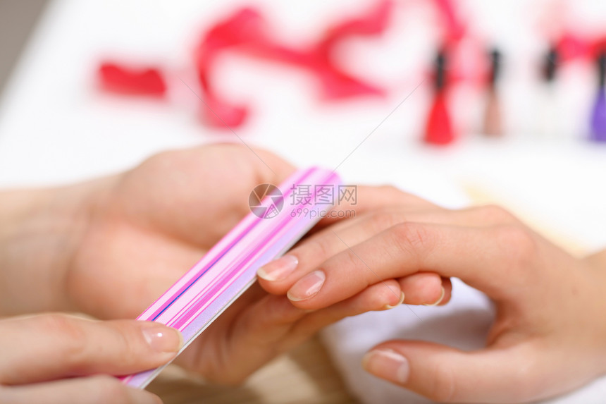 女人正在修指甲拇指毛巾抛光美甲沙龙护理魅力温泉手指福利图片
