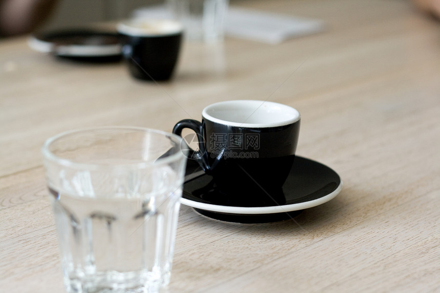 一杯黑咖啡和一杯水在桌子上玻璃饮料制品美食飞碟黑色白色陶瓷杯子陶器图片