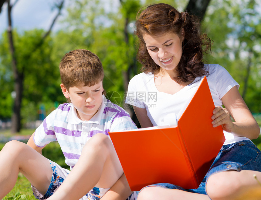一起阅读一本书教育微笑女性公园童年儿子幸福家庭乐趣闲暇图片