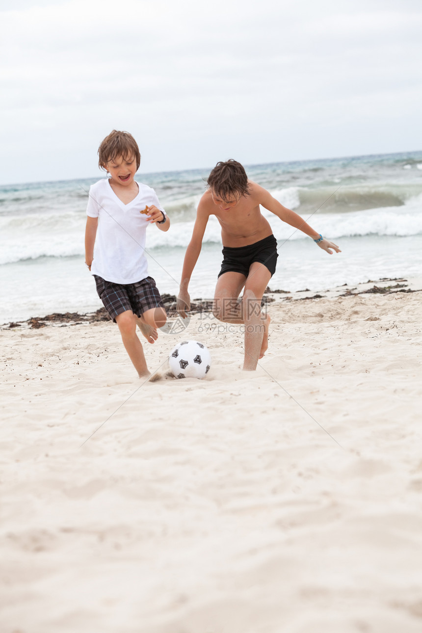 快乐的家庭父亲 两个孩子在沙滩夏天踢橄榄球成人童年娱乐男性喜悦儿子男生海滩乐趣微笑图片