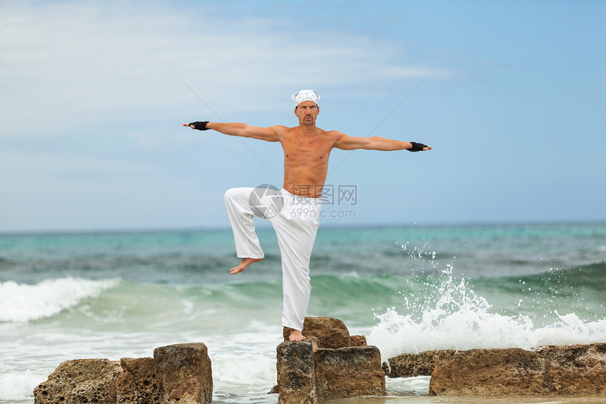 在沙滩做静脉瑜伽冥想的 健康人天空男性沉思放松石头蓝色男人训练精神成人图片