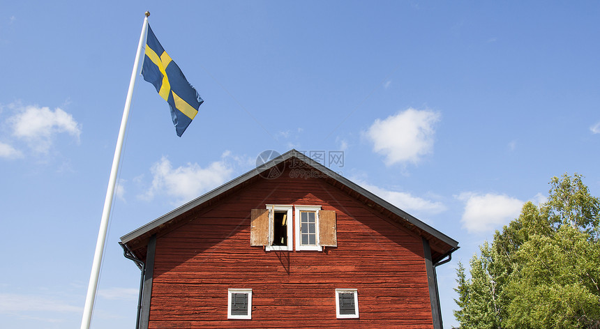 挂旗杆的老瑞典木屋日志农场红色建筑牧歌天空谷仓木板旗帜家园图片