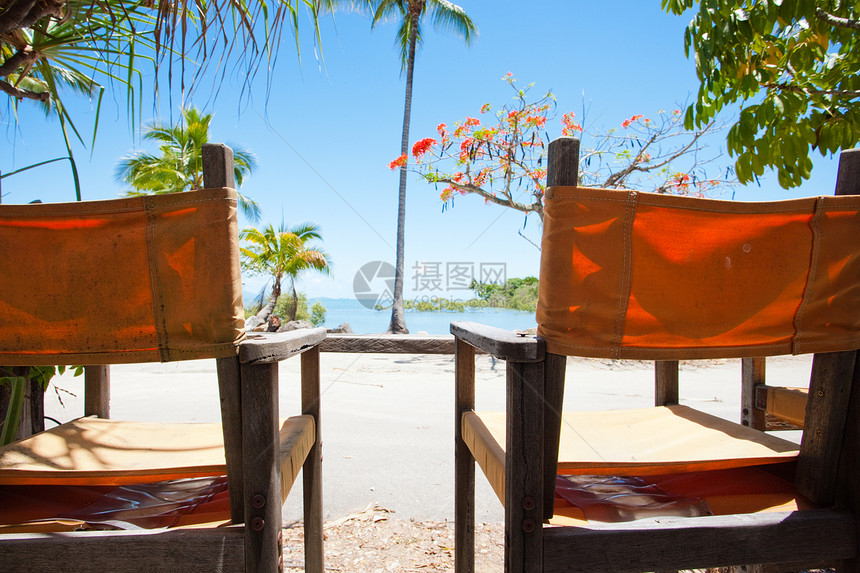 俯视热带海滩的两张甲板椅子图片