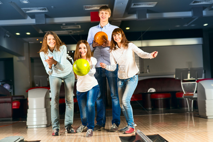一群玩保龄球的年轻朋友活动乐趣手臂女孩男人投球咖啡店竞赛投掷牛仔裤图片