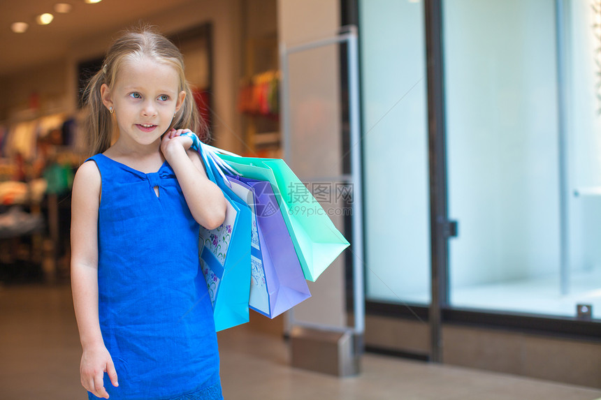 在商场拿着购物袋的小时装女孩的肖像微笑女性市场生活幸福快乐青年闲暇购买者乐趣图片
