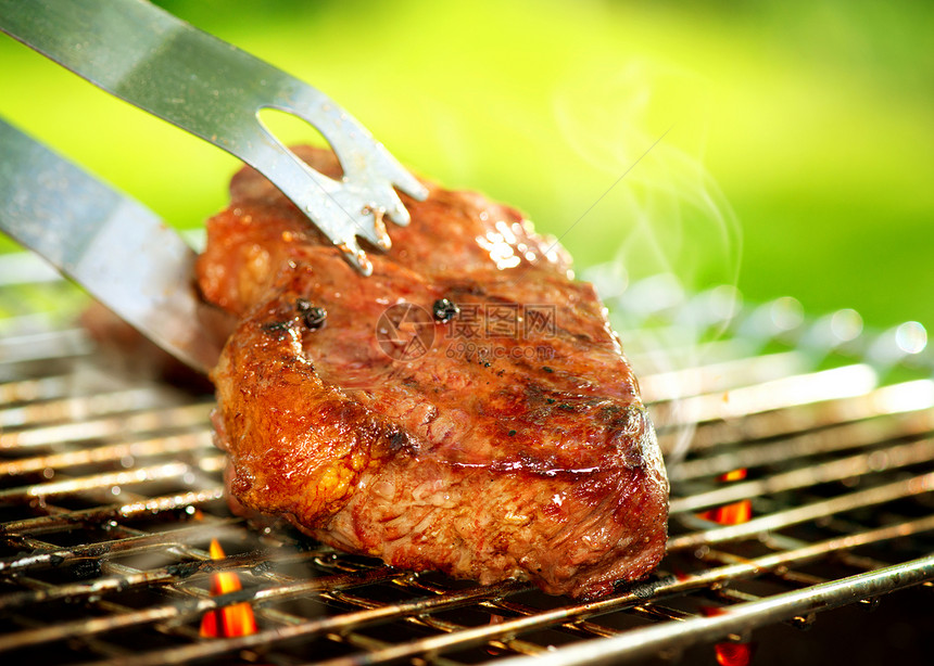 在BBQ上喷出一个牛排的火焰院子牛肉餐厅野餐烧烤菜单烧伤木炭食物美食图片