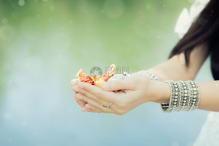 女孩手握糖果珠宝庆典女士样本诡计食物甜点诱惑传统手镯图片