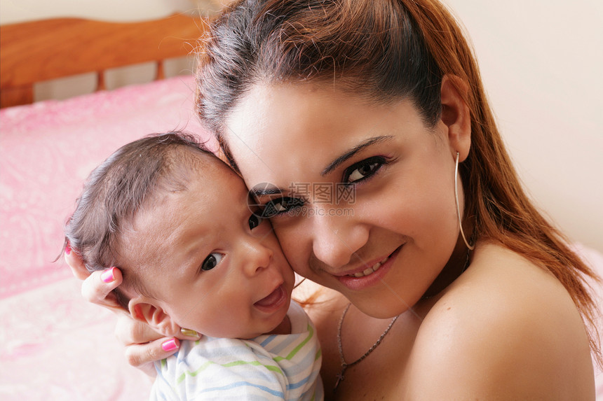 一位带着婴儿的西班牙籍快乐年轻母亲的肖像图片