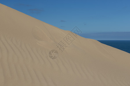 沙丘和蓝天线条热带天空侵蚀棕色蓝色沙漠海浪晴天海滩高清图片