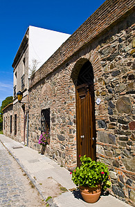 萨克尼亚乌拉圭 科洛尼亚旅游人行道历史角落建筑学石头街道殖民地遗产窗户背景