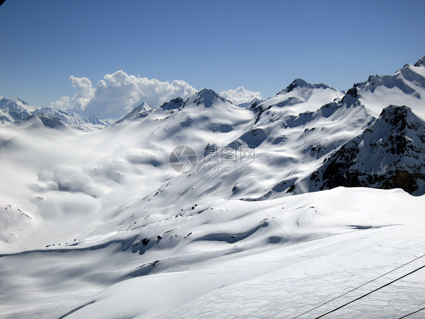 蓝天和云下高山石头天空季节滑冰危险白色天蓝色蓝色滑雪岩石图片