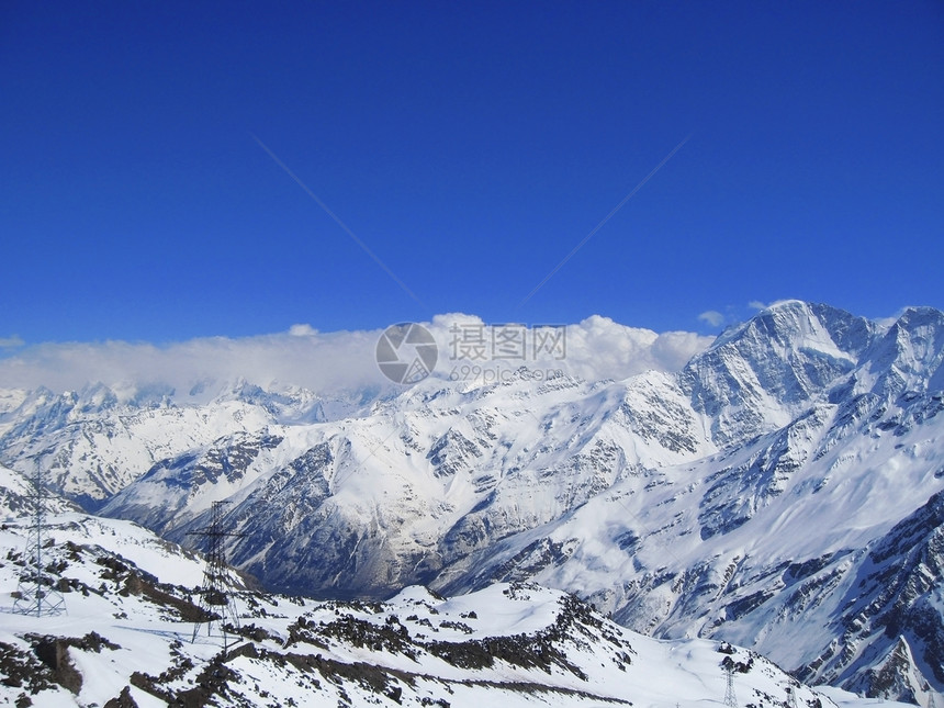 雪下和清空下的高加索山脉悬崖顶峰山脉运动白色爬坡滑雪蓝色季节石头图片