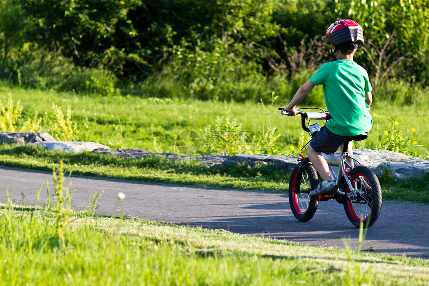 儿童骑自行车在公园的自行车路上运动闲暇踏板轮子孩子童年乐趣娱乐男生青年图片