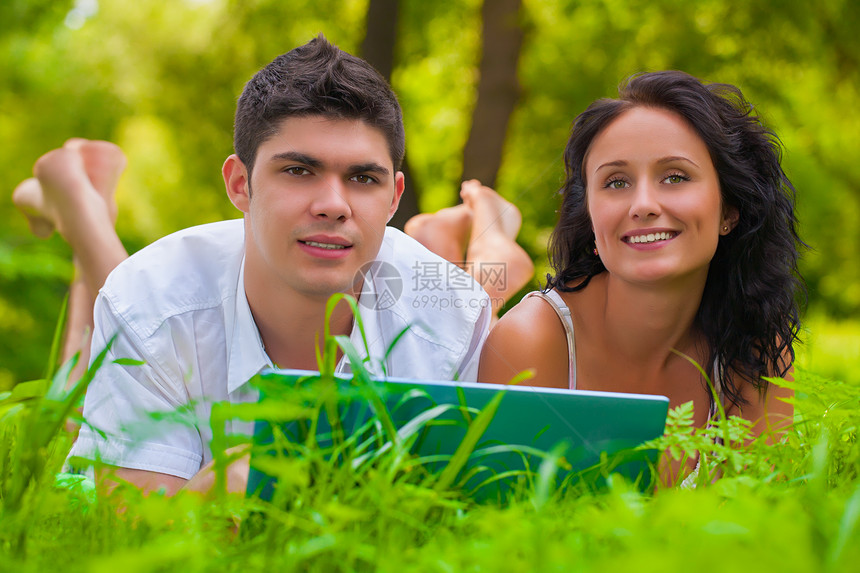 年轻夫妇在公园里躺着玩乐图片