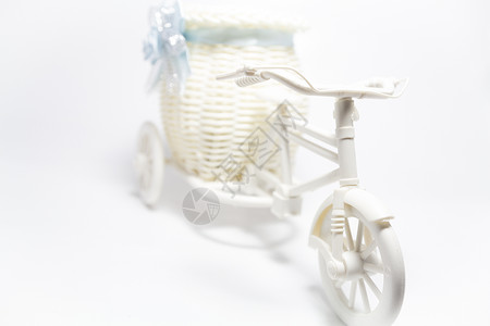 自行车玩具白色塑料展示篮子丝带蓝色背景图片