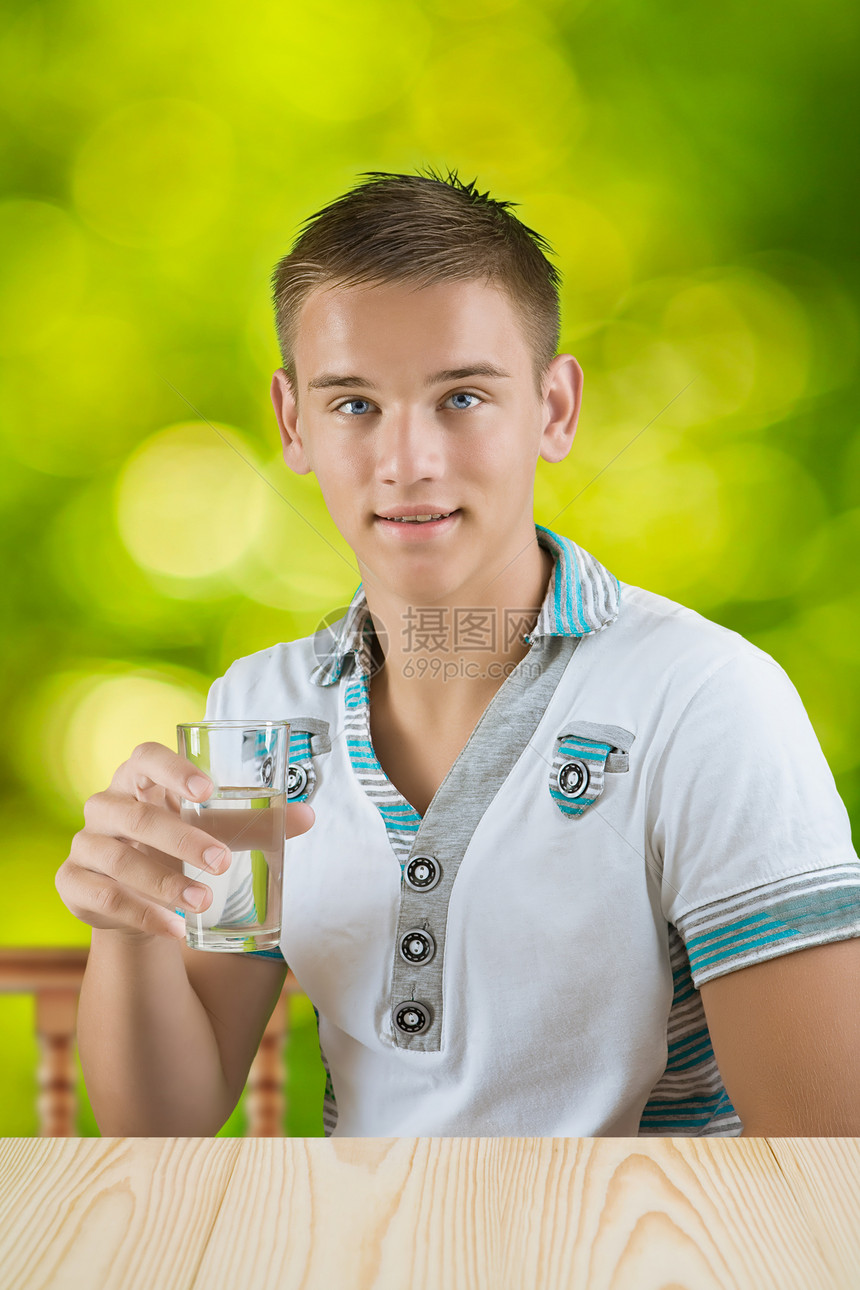 一个人拿着杯水桌子扶手青少年男性器皿玻璃背景运动蓝色活力图片