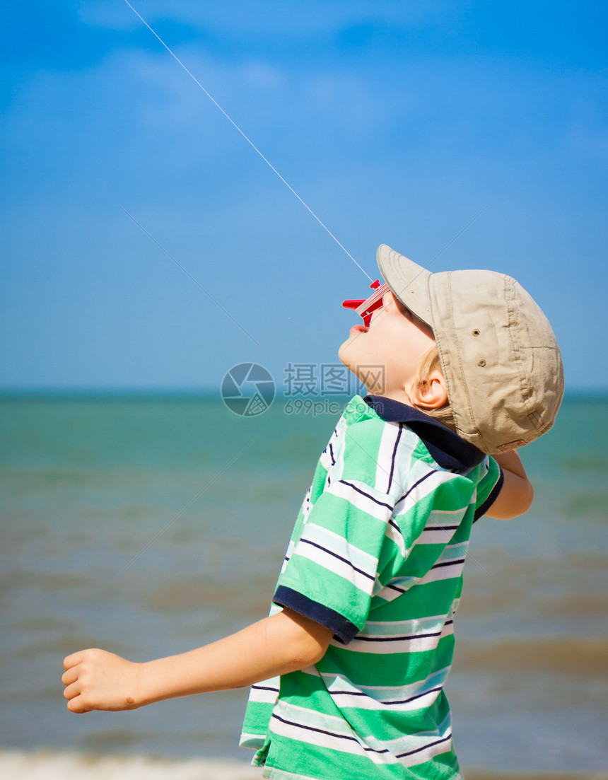 男孩在海滩上飞风筝图片