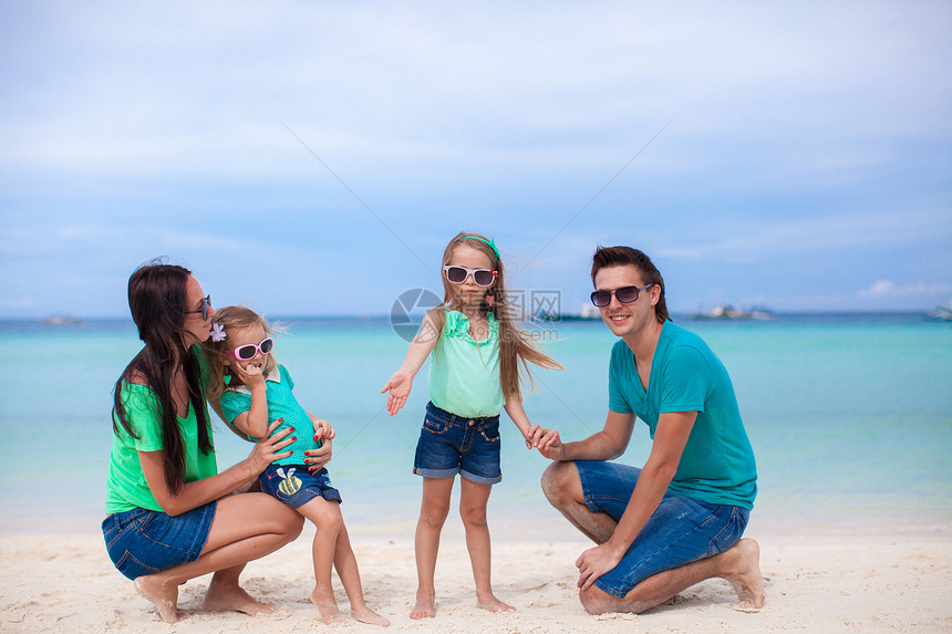 四口的年轻美丽家庭 享受沙滩上放松的快乐孩子假期旅游孩子们异国海岸父母婴儿女士女孩图片