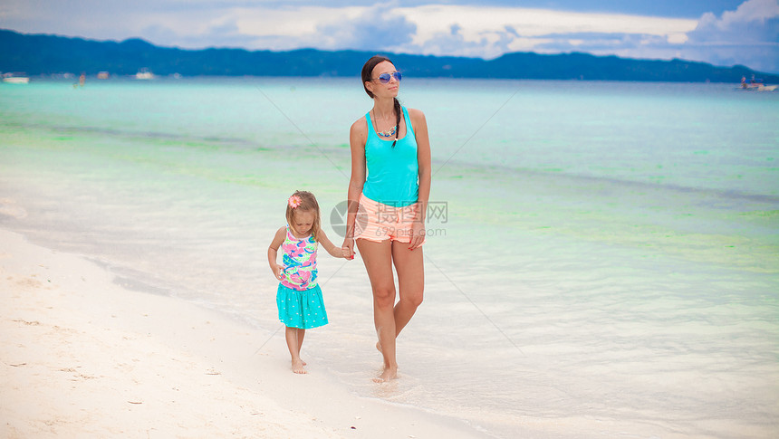 年轻母亲和她的小女儿在菲律宾海边散步时身着便衣图片