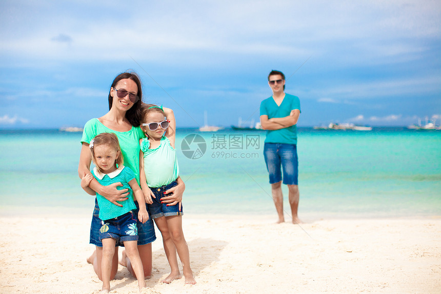 前景是妈妈和她可爱的女儿 背景是爸爸在海滩上婴儿乐趣母亲女孩女性海岸海洋父母女士情调图片