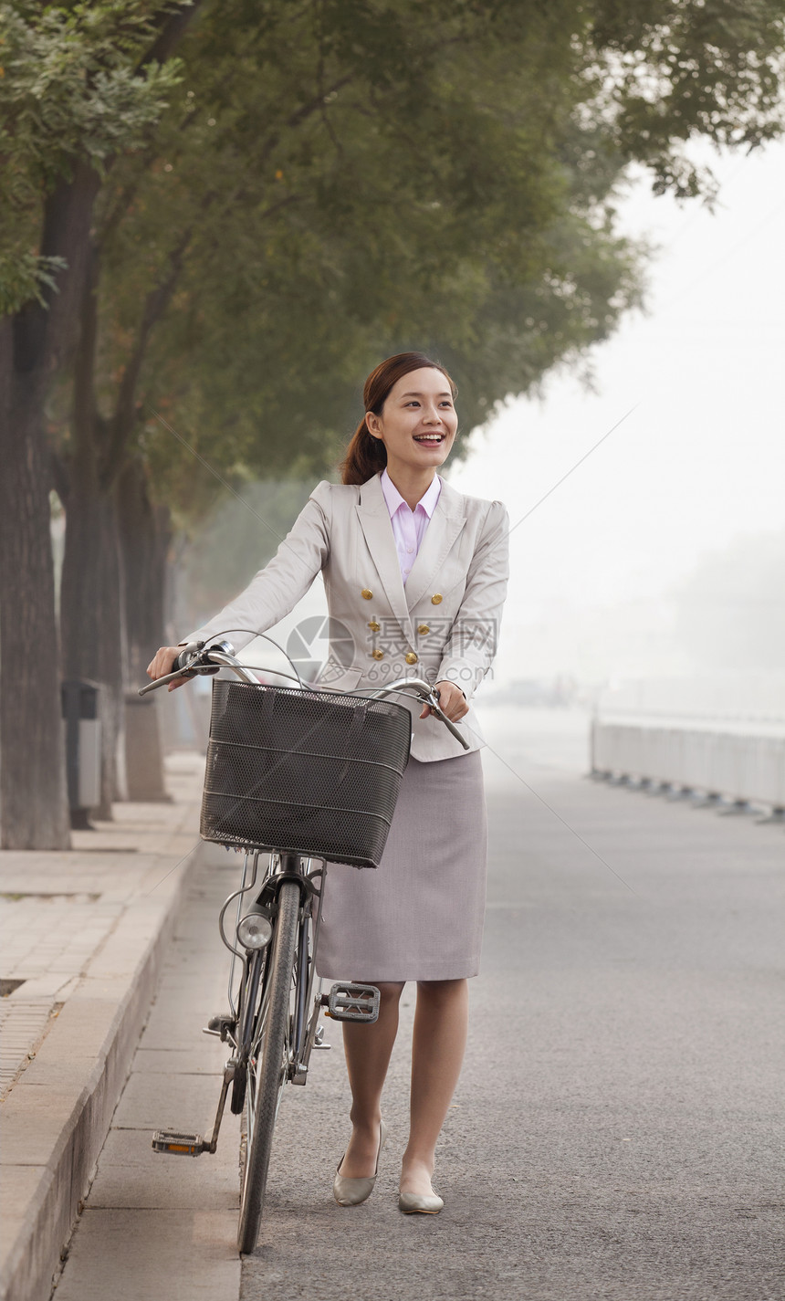 青年商业女商务人士与自行车搭乘的汽车 中国北京商务快乐衣冠幸福城市生活街道通勤者长发运动前景图片