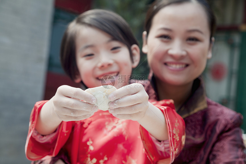 母亲和女儿在传统衣服中做面条 紧闭起来饺子家庭文化饮食棕色两个人喜悦食物乐趣幸福图片