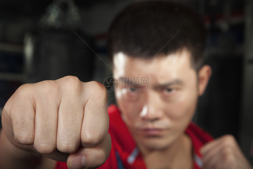 拳击手对着镜头打一拳部位健身房短发人类力量运动侵略能力韧性生活方式图片