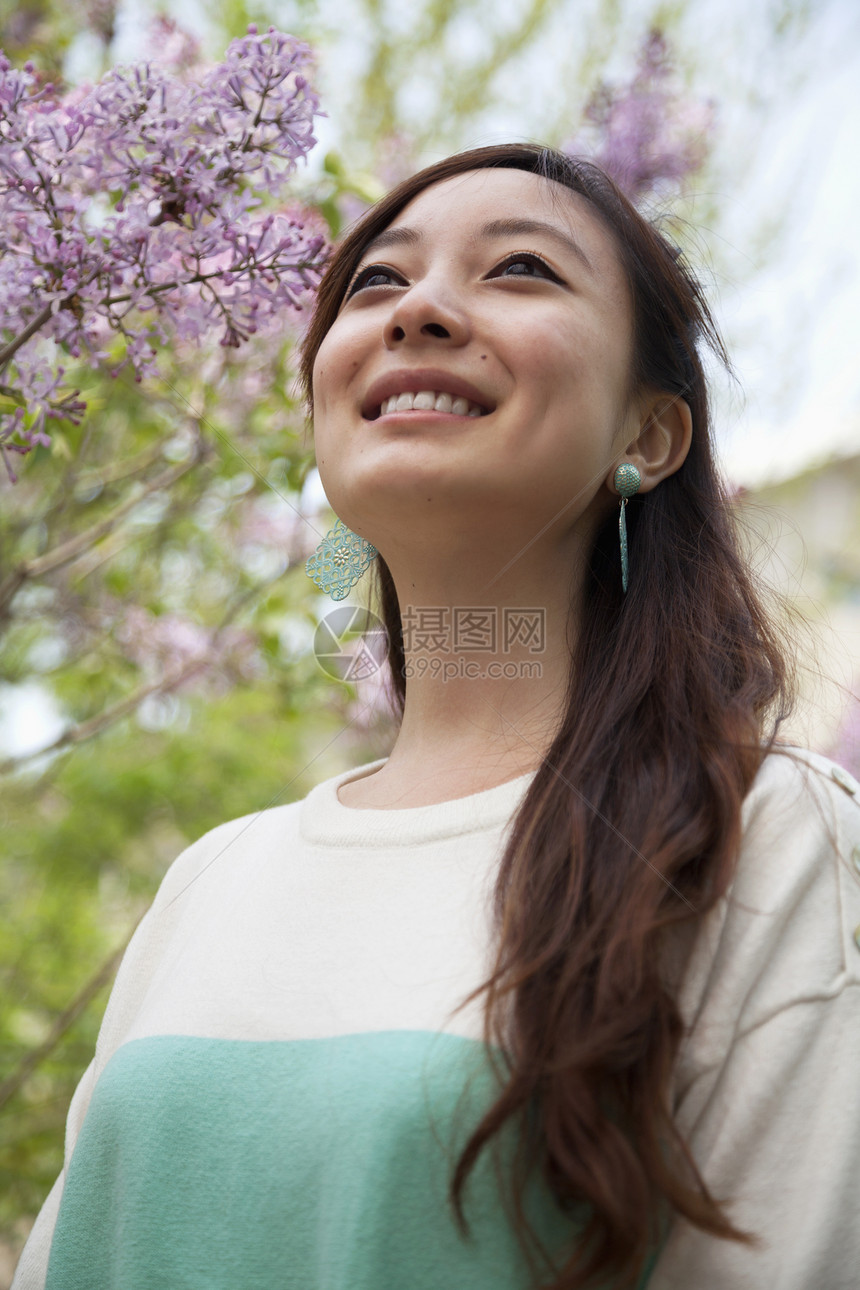 春天公园外露着长头发的微笑年轻女人的肖像 在公园里图片