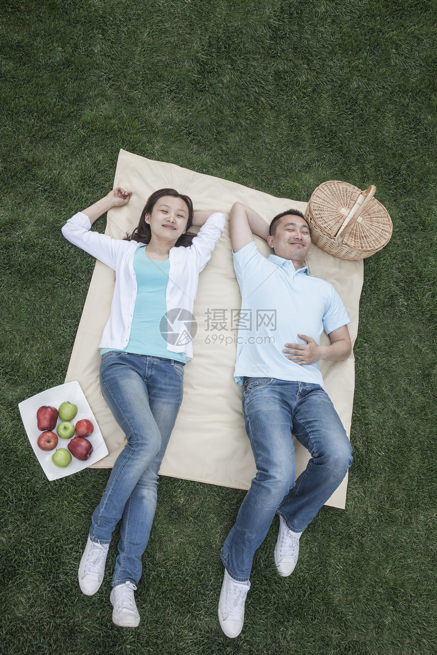 几个躺在野餐毯子上微笑公园两个人摄影团结省会活动草地篮子城市图片