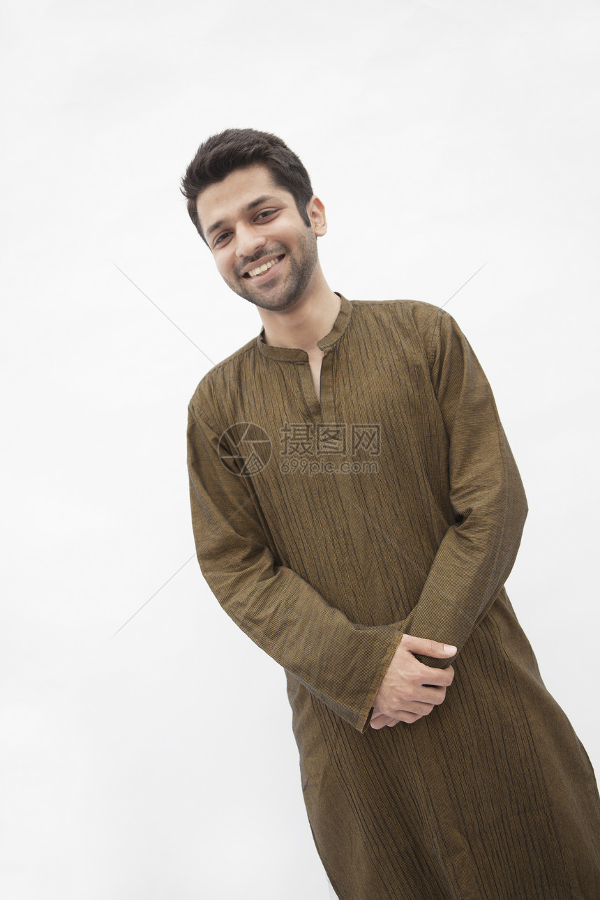 身着巴基斯坦传统服装 微笑的年轻男子的肖像 摄影棚拍摄幸福影棚棕色快乐身份长度文化绿色活力双手图片