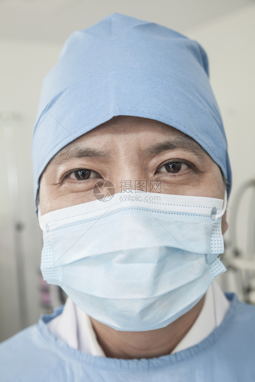 在手术室戴外科面具和外科帽的外科医生肖像防护专业工作服权威手术衣职业器材医护人员成年摄影图片