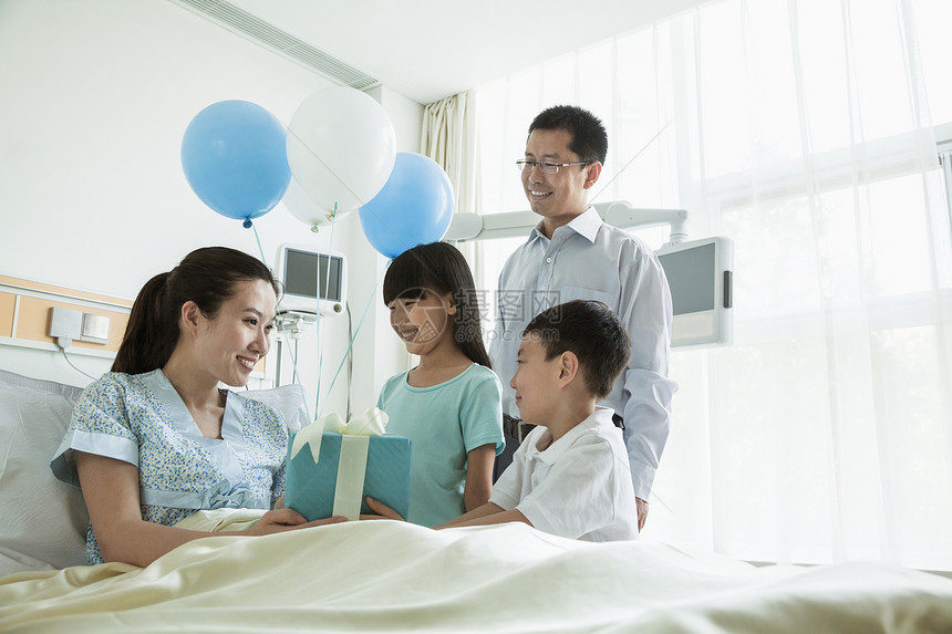 父亲和孩子去医院探望母亲 送礼物和气球图片