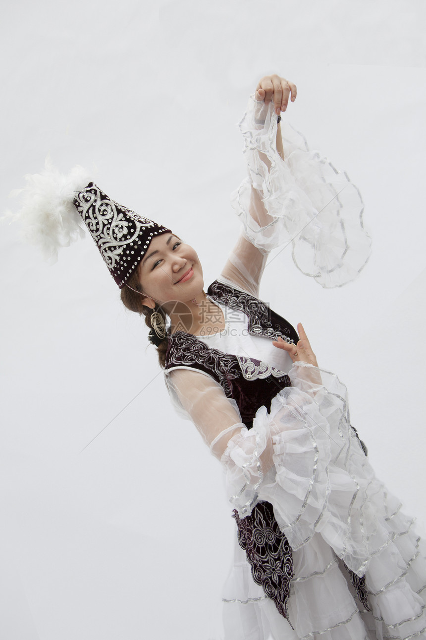 在哈萨克斯坦传统服装下跳舞的年轻微笑女性肖像 摄影棚拍摄镜头图片