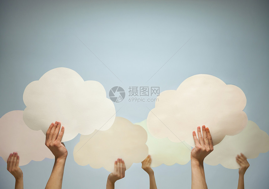 多手握着纸云 面对蓝色背景 摄影棚拍到的画面图片
