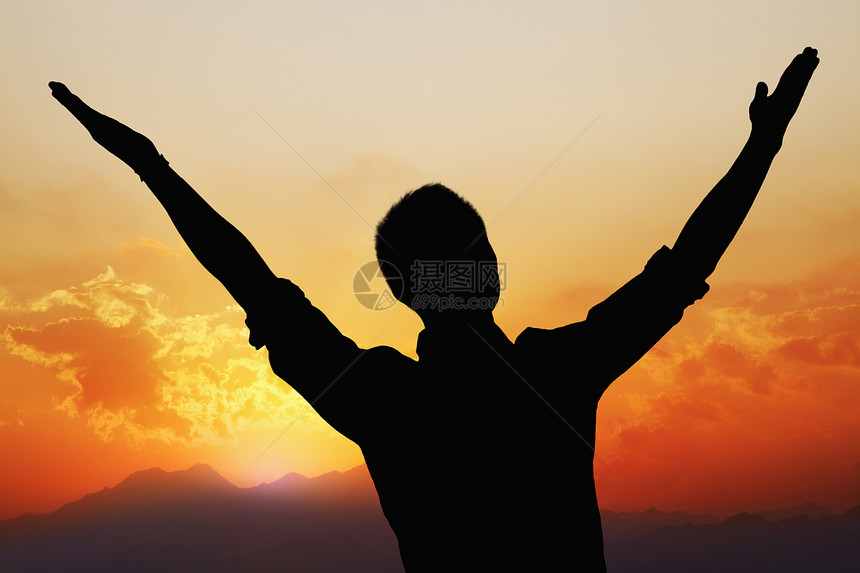 年轻男人的休眠 手举起手臂 美丽的日落和背景风景照亮图片