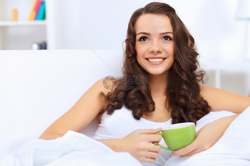 年轻女人在家喝茶的年青女人饮料玻璃女孩杯子青年快乐房子资源咖啡女性图片