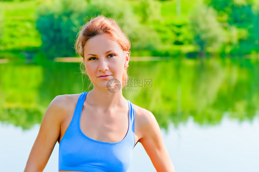 一个美丽的女孩的肖像在湖背景上的运动性质图片