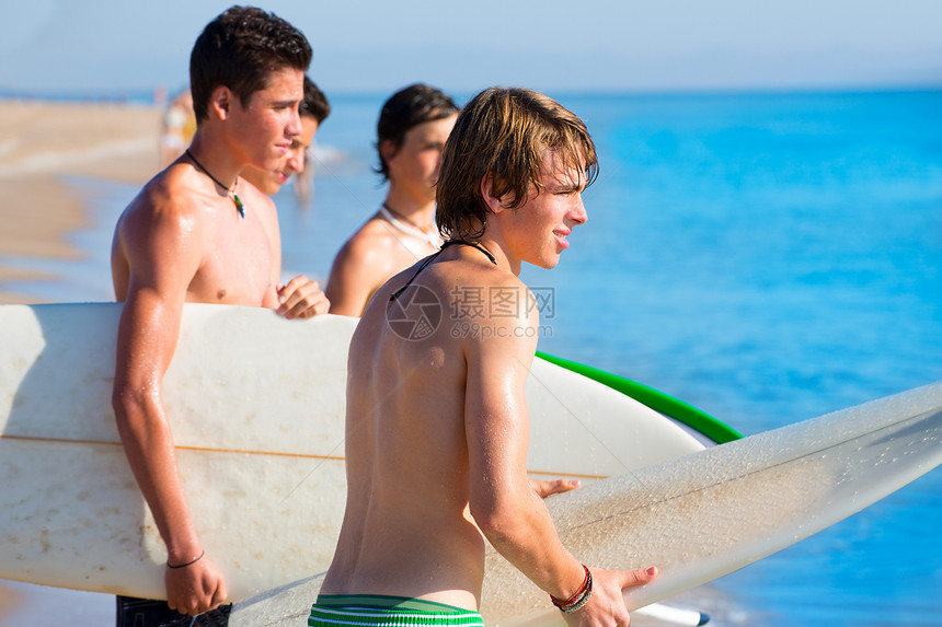 在海滩岸边聊天的少年男孩子阳光木板微笑太阳朋友们幸福青年男孩们支撑冲浪板图片